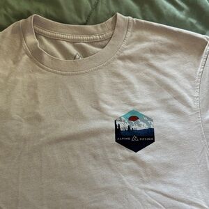 Alpine Design Men's Cream Tee with Scenic Logo